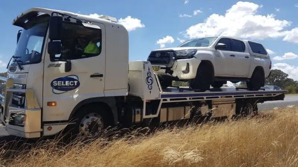 Broken-down car being towed by a flatbed truck in Sydney